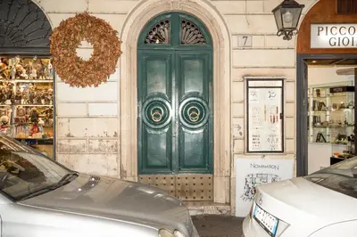 a green door on a building with cars in front at Sweet Roof Rhome in Rome