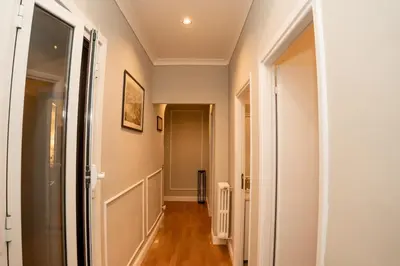 a hallway with white walls and wooden floors and a door at Sweet Roof Rhome in Rome