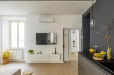 a kitchen with white cabinets and a tv on the wall at iFlat Sunny & Brand New Apartament near Vatican in Rome