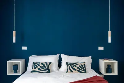 a blue bedroom with a bed with white sheets and pillows at iFlat Sunny & Brand New Apartament near Vatican in Rome