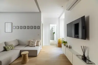 a white living room with a couch and a tv at iFlat Sunny & Brand New Apartament near Vatican in Rome