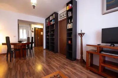 a living room with a table and a tv and bookshelves at Rialto Apartment Vatican Museums in Rome