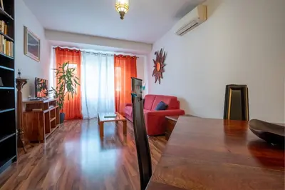 a living room with a red couch and a table at Rialto Apartment Vatican Museums in Rome