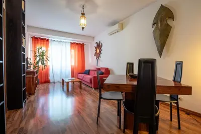 a living room with a wooden table and a red couch at Rialto Apartment Vatican Museums in Rome