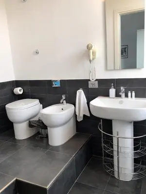 a bathroom with two sinks and a toilet and a mirror at The Manzoni in Rome