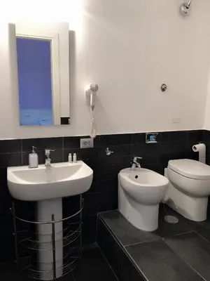 a bathroom with a sink and a toilet and a mirror at The Manzoni in Rome