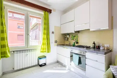 a kitchen with white cabinets and a stove top oven at Casa Sosò... La casa che fa per te! in Rome