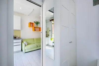 a living room with a green couch and a glass door at Casa Sosò... La casa che fa per te! in Rome