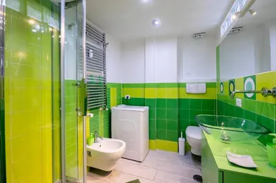 a green and white bathroom with a sink and a toilet at Casa Sosò... La casa che fa per te! in Rome