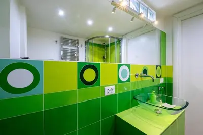 a green bathroom with a sink and a mirror at Casa Sosò... La casa che fa per te! in Rome