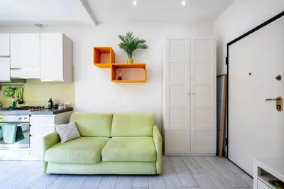a living room with a green couch in a kitchen at Casa Sosò... La casa che fa per te! in Rome