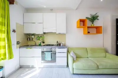 a kitchen with a green couch in a room at Casa Sosò... La casa che fa per te! in Rome