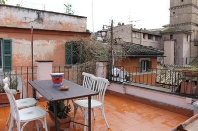 a table and chairs on the balcony of a building at Casa Greco - Attico con terrazza, Trastevere in Rome