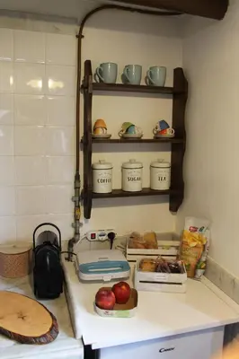 a kitchen counter with apples and bowls on shelves at Casa Greco - Attico con terrazza, Trastevere in Rome