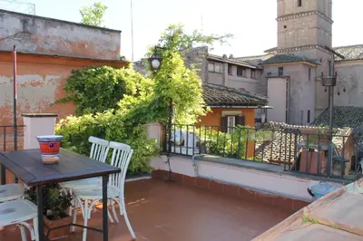 a balcony with a table and chairs on a building at Casa Greco - Attico con terrazza, Trastevere in Rome