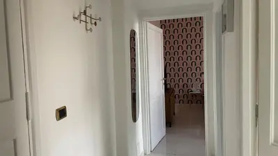 a hallway with a white hallway with a wall with a pattern at Good Time Apartment in Rome