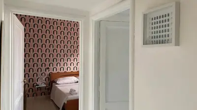 a bedroom with a bed and a wall with a door at Good Time Apartment in Rome