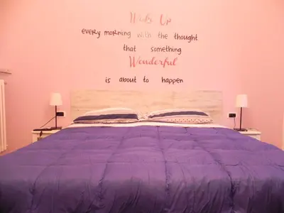 a bedroom with a purple bed with a quote on the wall at Vica Pota in Rome