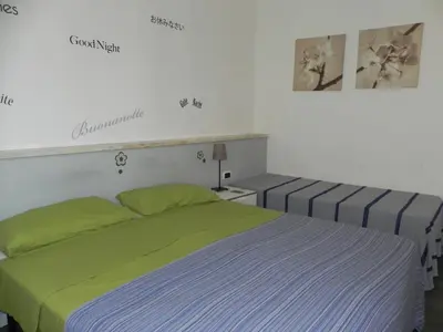 a bedroom with two beds with green and blue sheets at Vica Pota in Rome