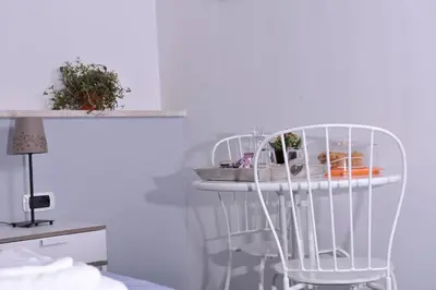 a white chair with a table with food on it at Vica Pota in Rome