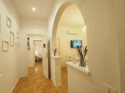 a hallway with an archway in a home with a television at VATICAN CITY 76 Apartment in Rome