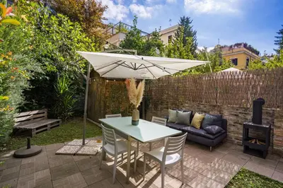 a patio with a table and an umbrella and a couch at Residenza Caprera in Rome