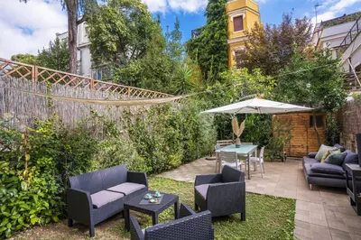 a patio with chairs and an umbrella and a table at Residenza Caprera in Rome
