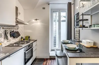 a kitchen with white appliances and a table with chairs at Residenza Caprera in Rome