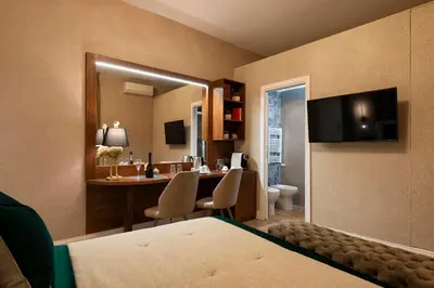 a hotel room with a bedroom with a desk and a mirror at Royal Rooms Corso in Rome