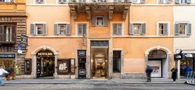 a building with shops on a street in a city at Royal Rooms Corso in Rome