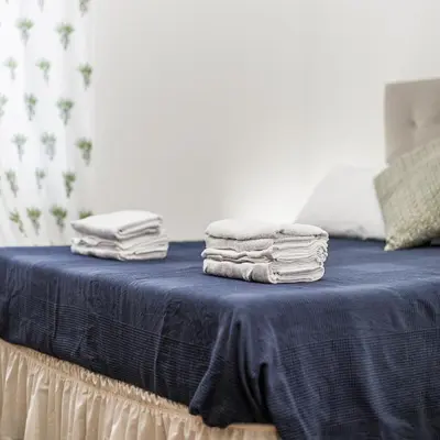 a pile of towels sitting on top of a bed at San Pietro Garden House in Rome