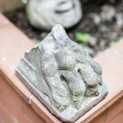 a statue of a hand on a ledge at San Pietro Garden House in Rome