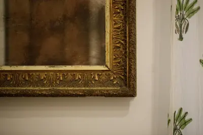 a gold picture hanging on a wall at San Pietro Garden House in Rome