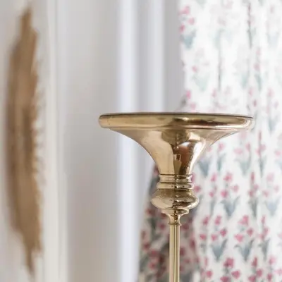 a gold candle holder in front of a window at San Pietro Garden House in Rome