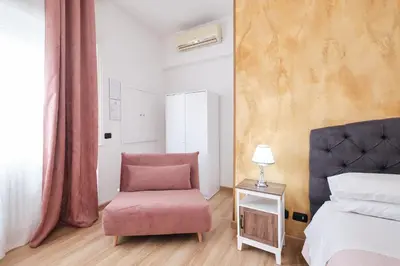 a bedroom with a pink chair and a bed at Il Pontefice Luxury in Rome