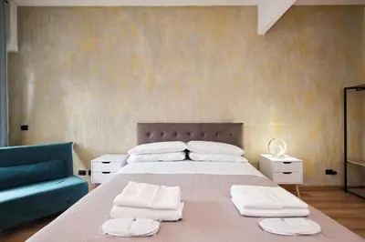 a bedroom with a large bed and a blue couch at Il Pontefice Luxury in Rome