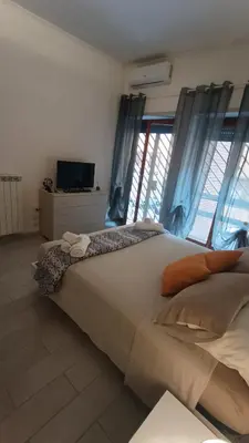 a bedroom with a large bed with blue curtains at Casilina One in Rome