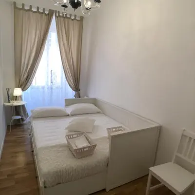 a white bedroom with a bed and a chair at Panorama suites & flats in Rome
