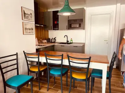 a kitchen with a wooden table with chairs and a kitchen with a sink at Luxury apartment Balduina - Casa di Irene in Rome