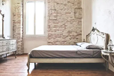 a bedroom with a bed and a brick wall at Casa Particular Vintage in Rome