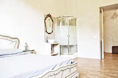 a white bedroom with a bed and a mirror at Casa Particular Vintage in Rome