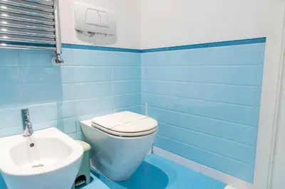 a blue bathroom with a toilet and a sink at Here's a new Laura's place - close to San Pietro in Rome