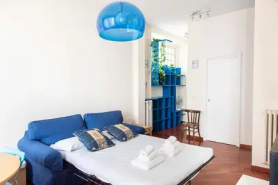 a blue couch in a living room with a table at Here's a new Laura's place - close to San Pietro in Rome