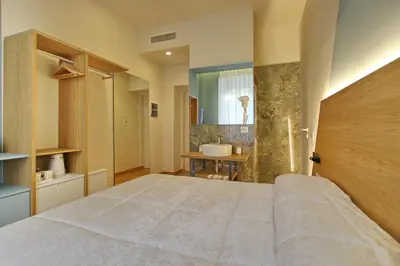 a bedroom with a large bed and a sink at Dea Rome Suites in Rome