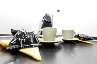 two coffee cups sitting on a table withacersacersangering at Emily a Roma home in Rome