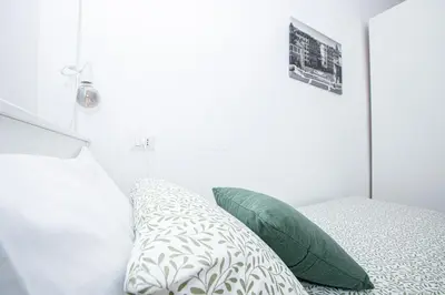 a bedroom with a bed with green and white pillows at Emily a Roma home in Rome