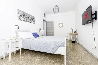 a white bedroom with a bed and a desk at Emily a Roma home in Rome