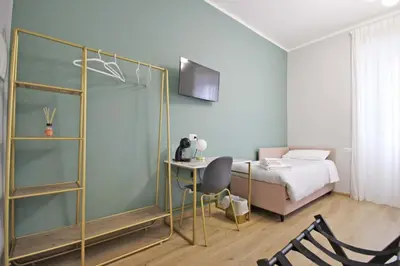 a bedroom with a bed and a desk with a chair at Roma Nostra Luxury B&B in Rome