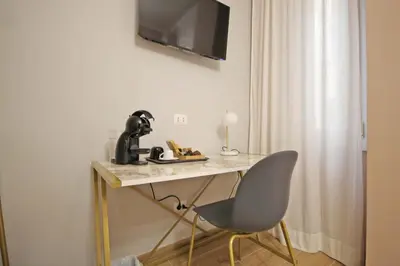 a desk with a chair and a television on a wall at Roma Nostra Luxury B&B in Rome