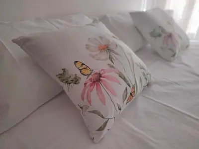 a pillow with flowers and a butterfly on a bed at RIPOLI APARTMENT in Rome